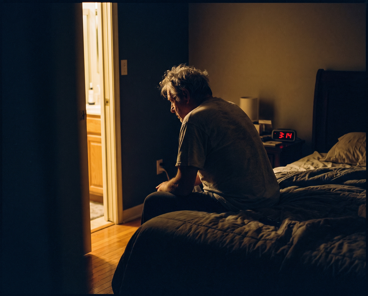 A man sitting on the edge of his bed at 3am